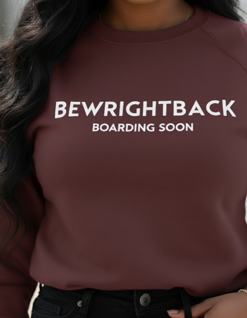 Maroon sweatshirt with 'BEWRIGHTBACK BOARDING SOON' text worn by a person.