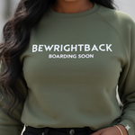 Person wearing a green sweatshirt with 'BEWRIGHTBACK BOARDING SOON' text